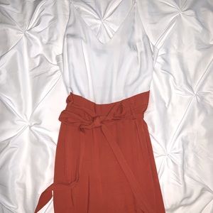 White top, burnt orange pants jumpsuit